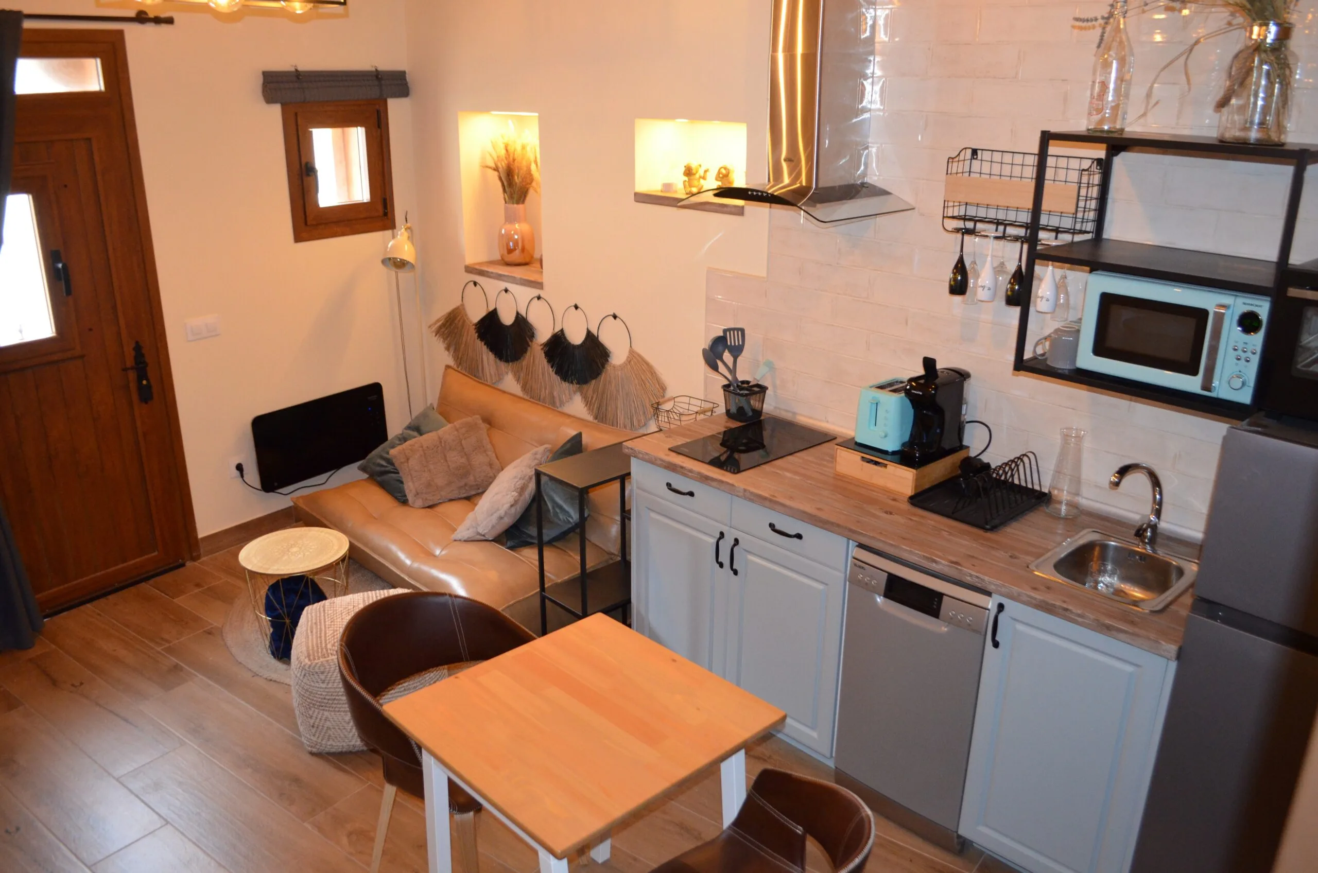 Salón con sofá y cocina en Casa Rural El Balcón del Castillo